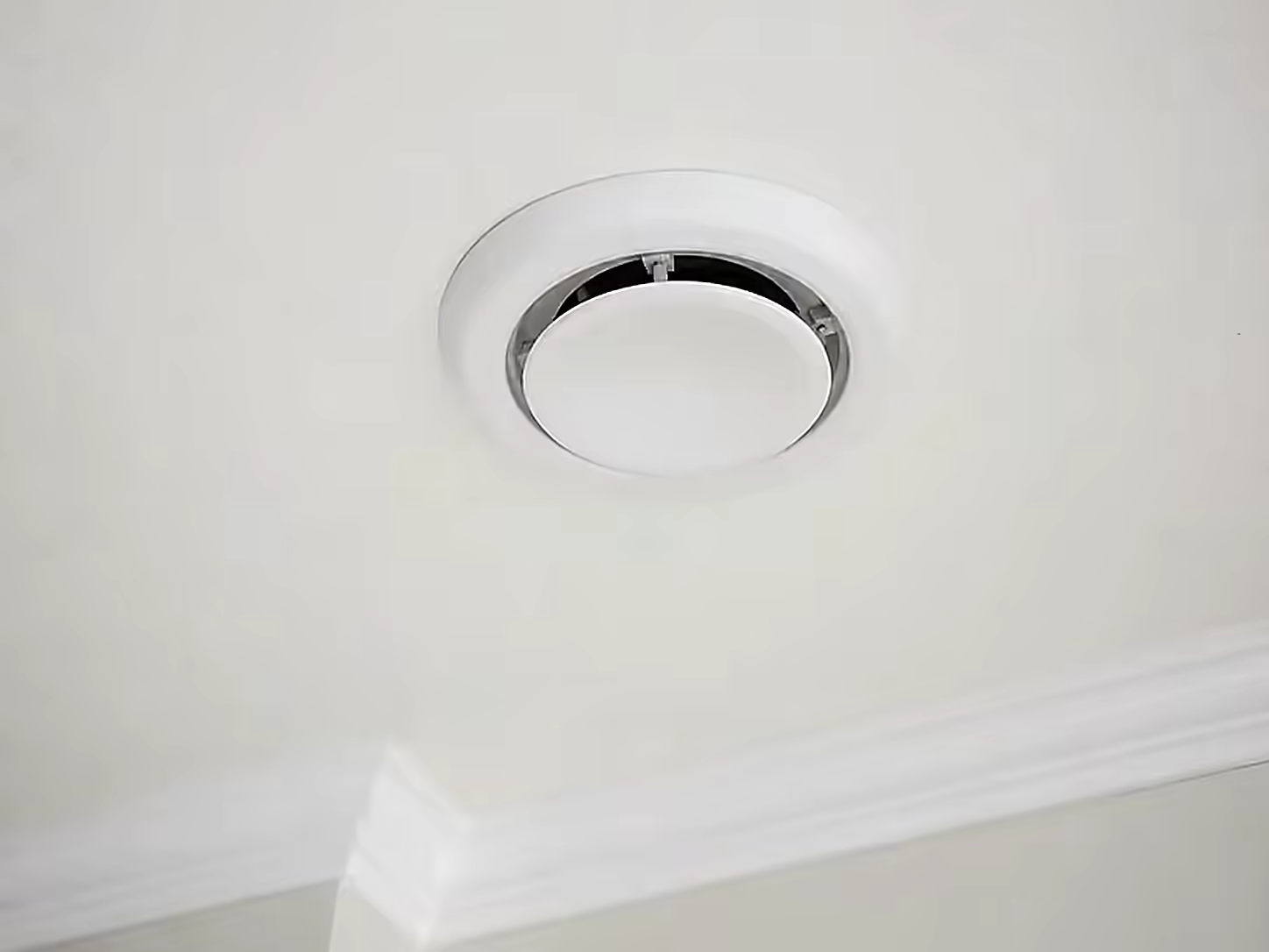 Bouche de ventilation encastrée dans un plafond fraîchement peint