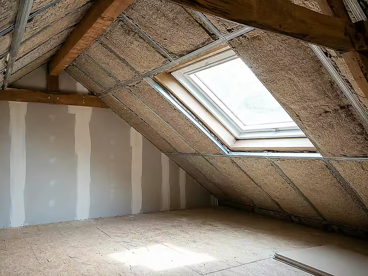Combles aménagés éclairés par une fenêtre de toit, rampants isolés et plancher posé