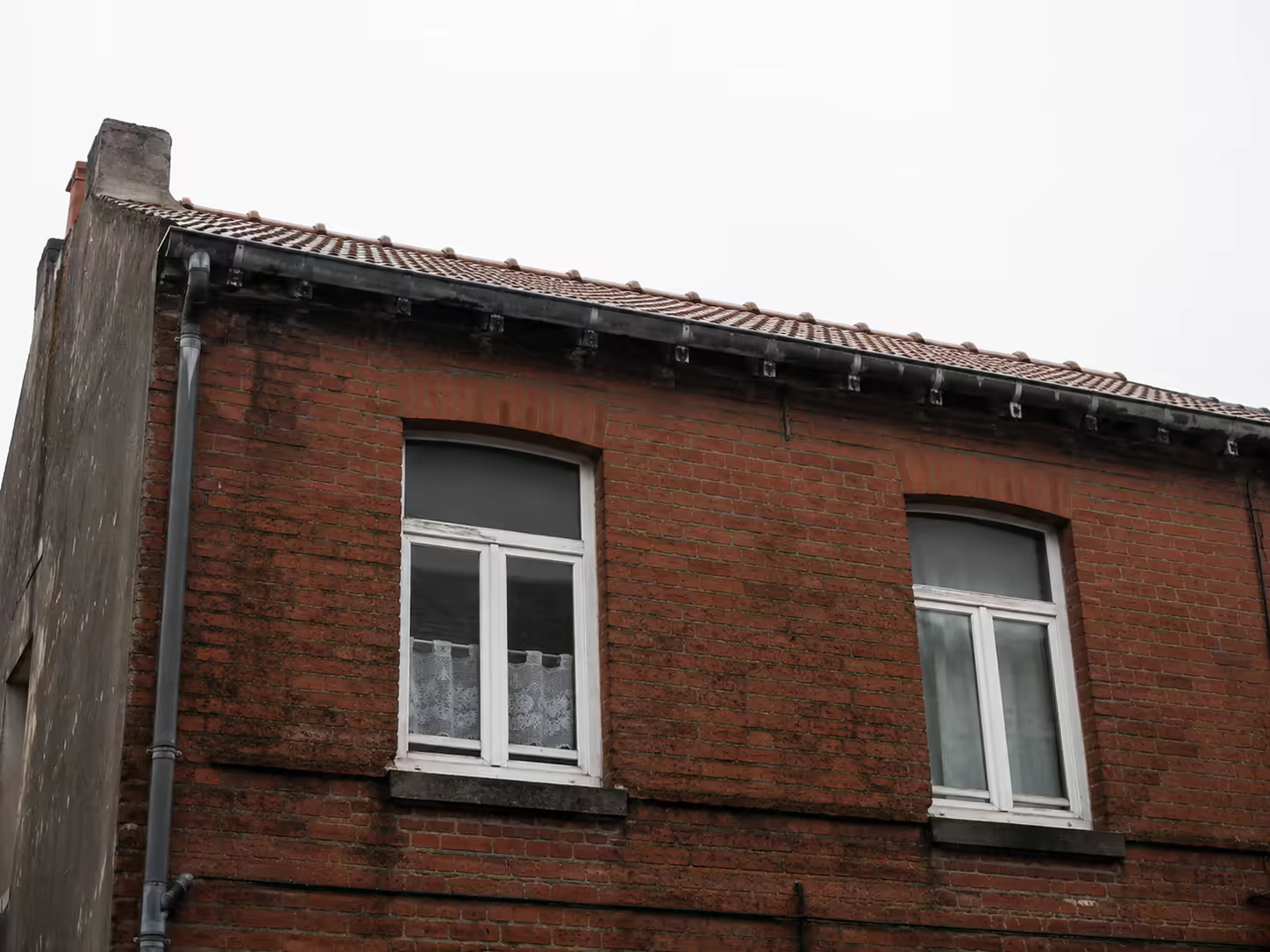 Façade dunkerquoise exposée au vent et à la pluie avec menuiseries et rives de toiture visibles