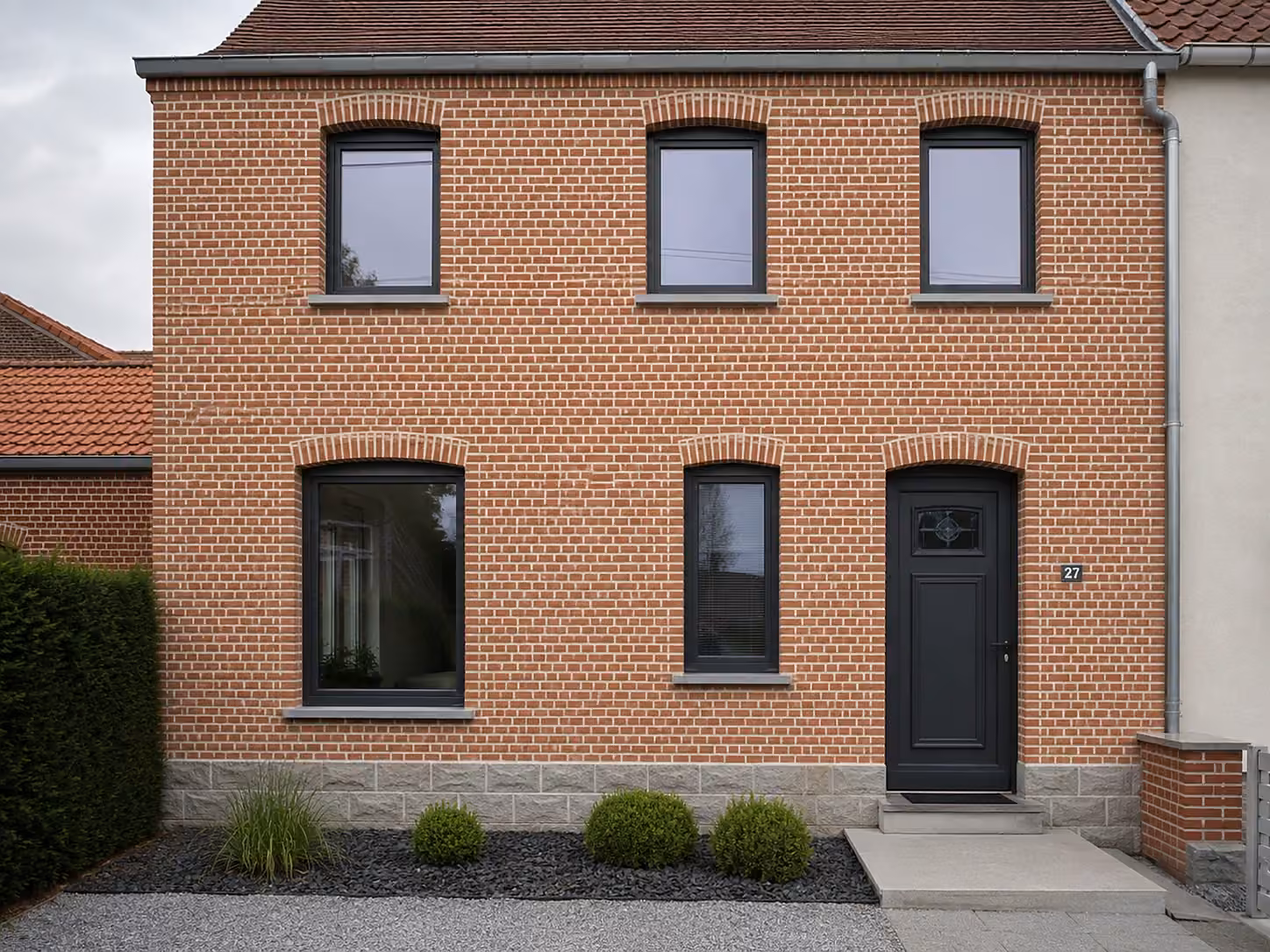 Maison de brique aux menuiseries noires, typique du bassin minier