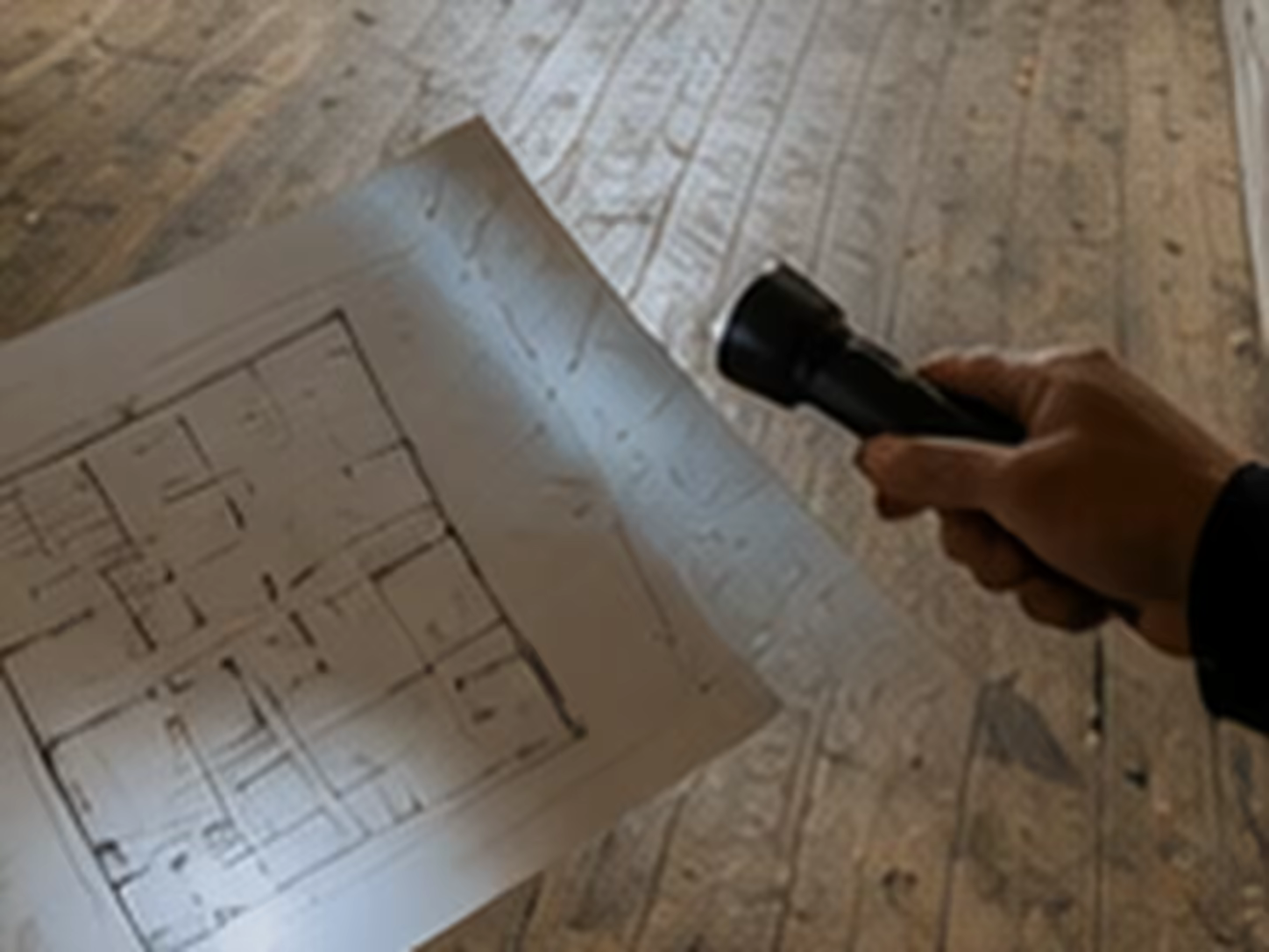 jeune propriétaire visitant une maison ancienne avec plans et relevés techniques