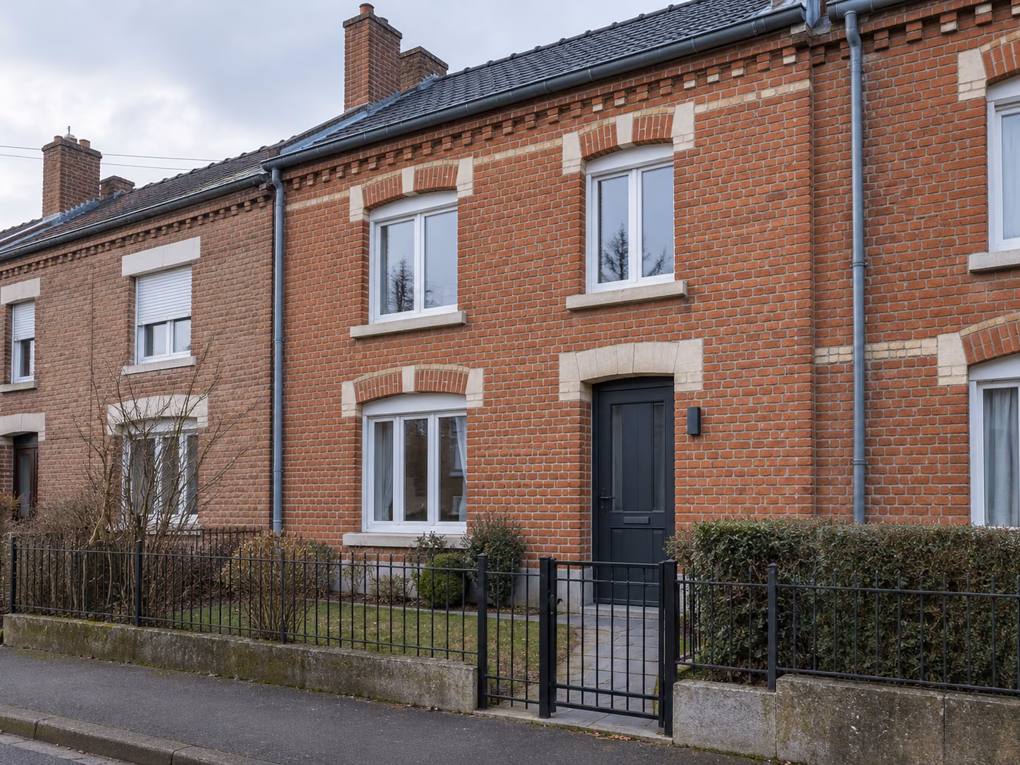 Une maison de mineur restaurée avec jardin devant, clôture basse, brique nettoyée, menuiseries neuves