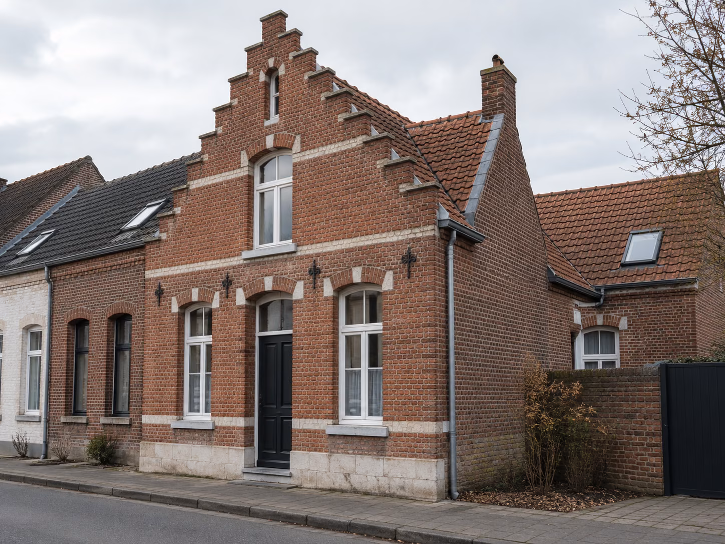 Une maison flamande à pignon sur rue, brique rouge et pierre blanche, fenêtres à petits bois