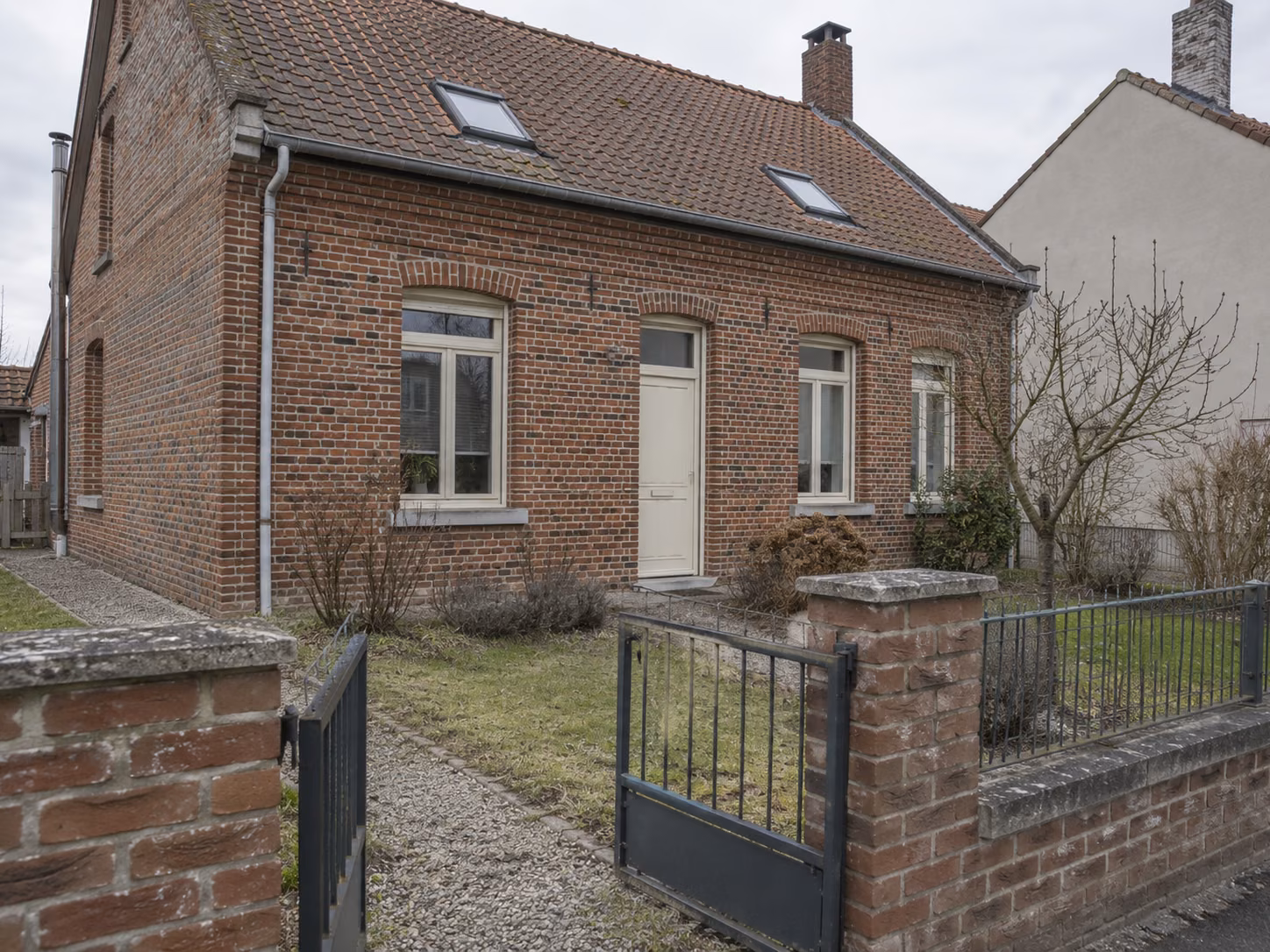 Une maison de mineur restaurée avec jardin devant, clôture basse, brique nettoyée, menuiseries neuves