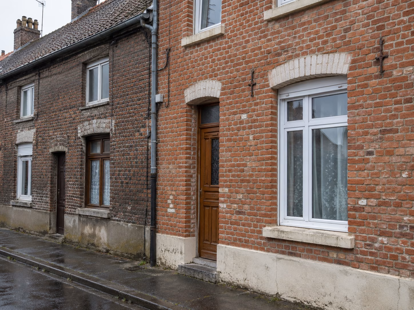Une façade en brique avec un ravalement récent d’un côté et une façade voisine non traitée, contraste visible