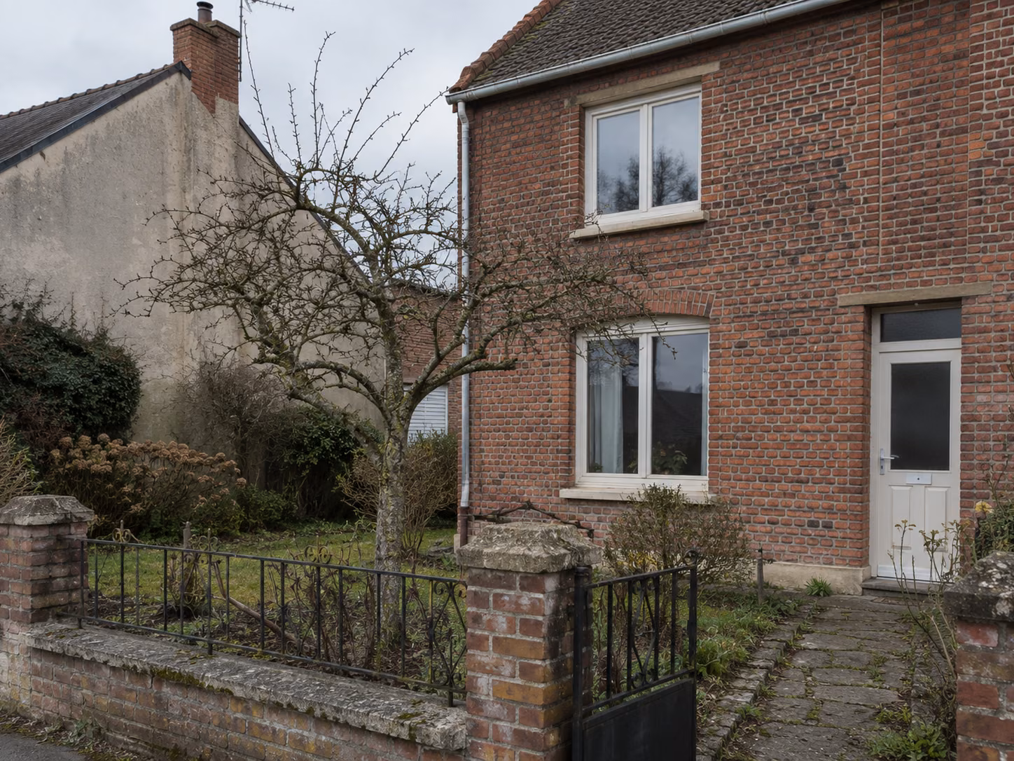 Une maison de mineur restaurée avec jardin devant, clôture basse, brique nettoyée, menuiseries neuves